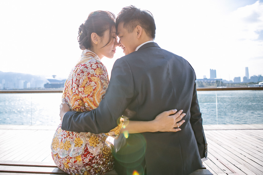 bride and groom posing for a photo on victoria harbour near the royal garden